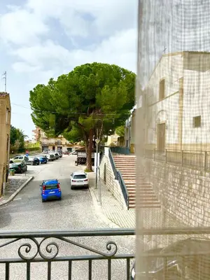 a view from a window of a parking lot with a tree at La Casa del Sole in Corleone