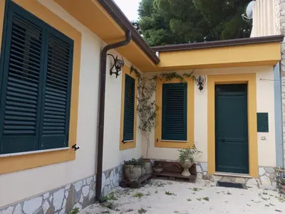 a house with two blue doors and some plants at Mami house in Sambuca di Sicilia