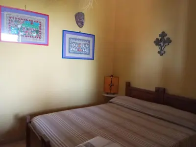 a bedroom with a bed and two pictures on the wall at Mami house in Sambuca di Sicilia