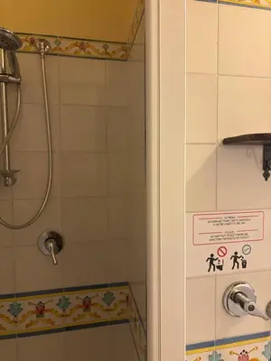 a shower in a bathroom with a sign on the door at da Mimì in San Vito lo Capo