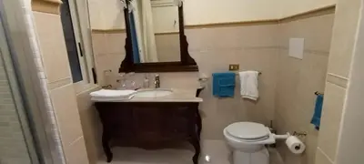 a bathroom with a sink and a toilet and a mirror at Suite Conte di Cavour in Palermo