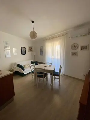 a living room with a table and chairs and a couch at Casa Bluet on the Sea in Balestrate