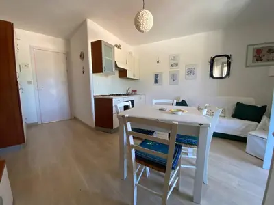 a kitchen and living room with a table and chairs at Casa Bluet on the Sea in Balestrate