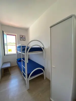 a bunk bed room with two bunk beds and a window at Casa Bluet on the Sea in Balestrate