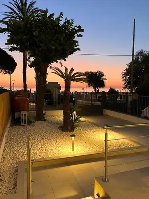 a parking lot with palm trees and a light at Regina Elena Luxury Apartments in Mondello
