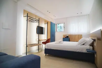 a bedroom with a bed and a desk and a tv at Regina Elena Luxury Apartments in Mondello