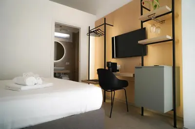 a hotel room with a bed and a desk at Regina Elena Luxury Apartments in Mondello
