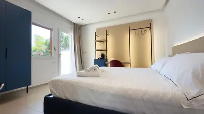a bedroom with a large white bed and a window at Regina Elena Luxury Apartments in Mondello