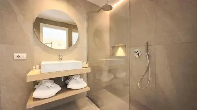 a bathroom with a sink and a shower with a mirror at Regina Elena Luxury Apartments in Mondello