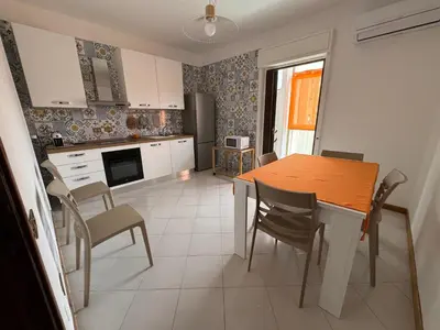 a kitchen with a table and chairs in a kitchen at Castelforte House in Palermo