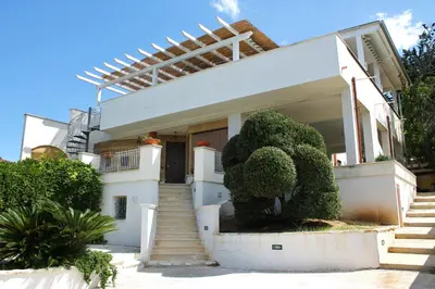 a white house with stairs and trees in front of it at Baia del Sol Balestrate in Balestrate