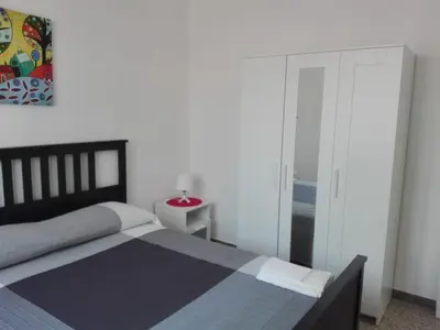 a bedroom with a bed and a glass door at Higgie House in Palermo