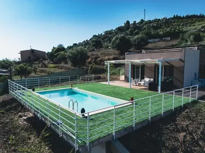 a swimming pool on the side of a house at The Villa - Lascari Cefalu' in Lascari