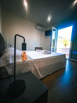 a bedroom with a bed and a lamp on a table at The Villa - Lascari Cefalu' in Lascari