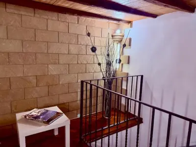 a room with a staircase with a vase and a table at La dimora di Aurora in Palermo