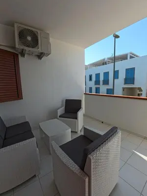 a balcony with chairs and a table and a heater at Ciatu di Suli in San Vito lo Capo