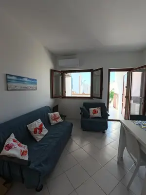 a living room with a blue couch and a table at Ciatu di Suli in San Vito lo Capo