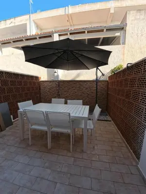 a table and chairs with an umbrella on a patio at Ciatu di Suli in San Vito lo Capo