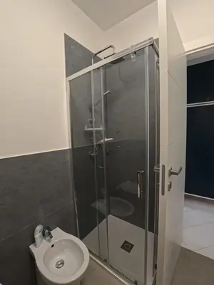 a bathroom with a glass shower and a toilet at Ciatu di Suli in San Vito lo Capo