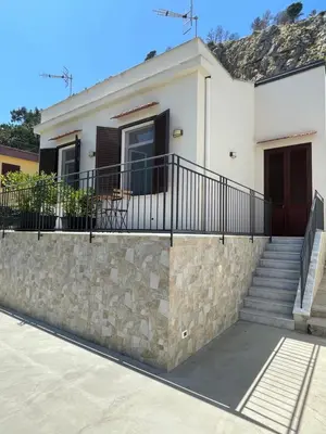 a white house with a stone wall and stairs at Casa Totino Mondello in Palermo