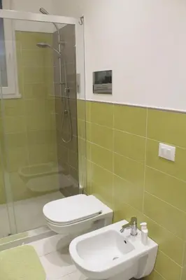 a bathroom with a toilet and a sink and a shower at Casa Totino Mondello in Palermo