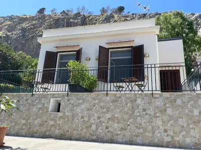 a house on a stone wall with a balcony at Casa Totino Mondello in Palermo