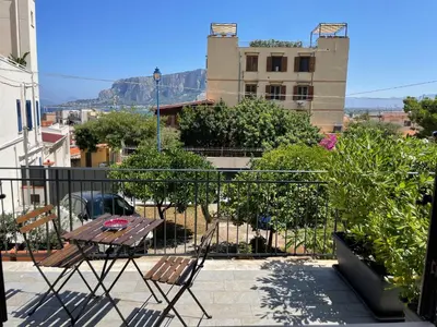 a patio with a table and chairs on a balcony at Casa Totino Mondello in Palermo