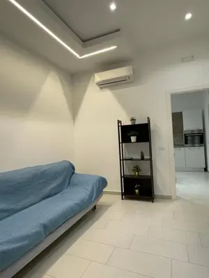 a bedroom with a blue bed and a black shelf at Casa Carmela Mondello in Palermo