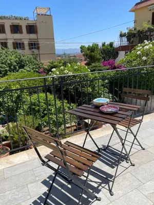 a wooden table and a chair on a balcony at Casa Carmela Mondello in Palermo