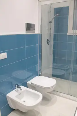 a bathroom with a toilet and a shower and a sink at Casa Carmela Mondello in Palermo