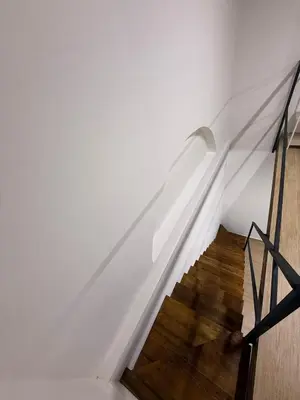 a stairway with a white wall and wooden floors at La Dimora del CAPO in Palermo