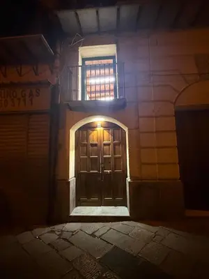 a door of a building at night with a window at La Dimora del CAPO in Palermo