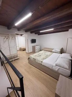 a bedroom with a large bed and a chair at La Dimora del CAPO in Palermo
