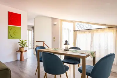 a dining room with a wooden table and blue chairs at Apartment with 2 Terraces near Teatro Massimo in Palermo