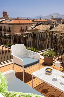 a patio with two chairs and a table on a balcony at Apartment with 2 Terraces near Teatro Massimo in Palermo