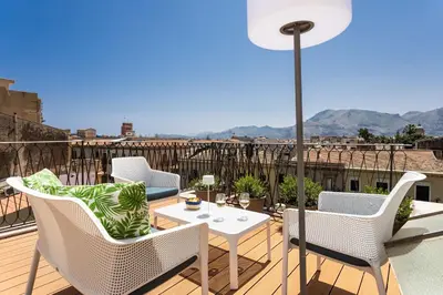 a balcony with chairs and a table with a view at Apartment with 2 Terraces near Teatro Massimo in Palermo