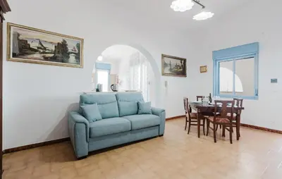 a living room with a blue couch and a table at Stunning Apartment In Balestrate in Balestrate