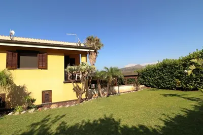 a yellow house with a lawn in front of it at Villa Belorizzonte - Relax & Sea in Mandra Capreria