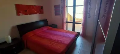 a bedroom with a red bed and a window at Villa Belorizzonte - Relax & Sea in Mandra Capreria