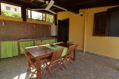 a kitchen with a wooden table and chairs in a room at Villa Belorizzonte - Relax & Sea in Mandra Capreria
