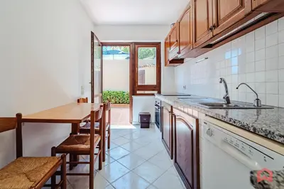 a kitchen with a sink and a wooden table at Delizioso Appartamento in villa & Piscina Privata in Trabia
