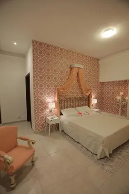 a bedroom with a large bed and a chair at Antica Palermo R&B in Palermo