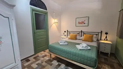 a bedroom with a green bed with towels on it at Barbarò Apartments in Palermo
