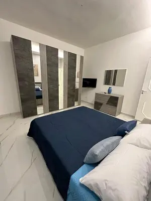 a bedroom with a large bed with blue sheets and pillows at Vitale House in Borgetto