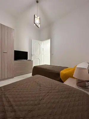 a hotel room with two beds and a television at Vitale House in Borgetto