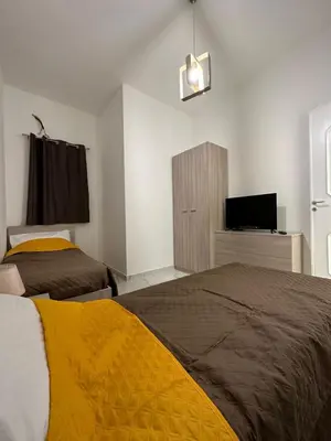 a bedroom with two beds and a flat screen tv at Vitale House in Borgetto