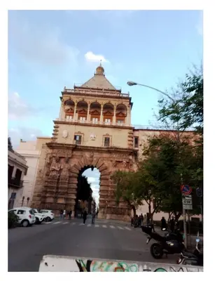 a building with an arch in the middle of a street at City-Inn II with 2 comfortable single beds in Palermo