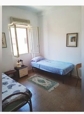 a bedroom with two beds and a window at City-Inn II with 2 comfortable single beds in Palermo