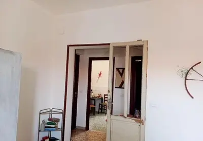 a hallway with an open door and a room with a table at City-Inn II with 2 comfortable single beds in Palermo