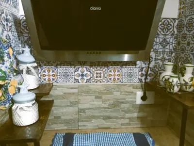 a bathroom with a tv on a tiled wall at A meravigghia casa vacanze in Bagheria